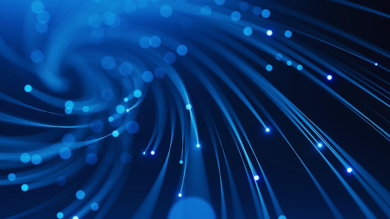 Nahaufnahme von leuchtenden Glasfaserkabeln mit Lichtpunkten auf dunklem Hintergrund